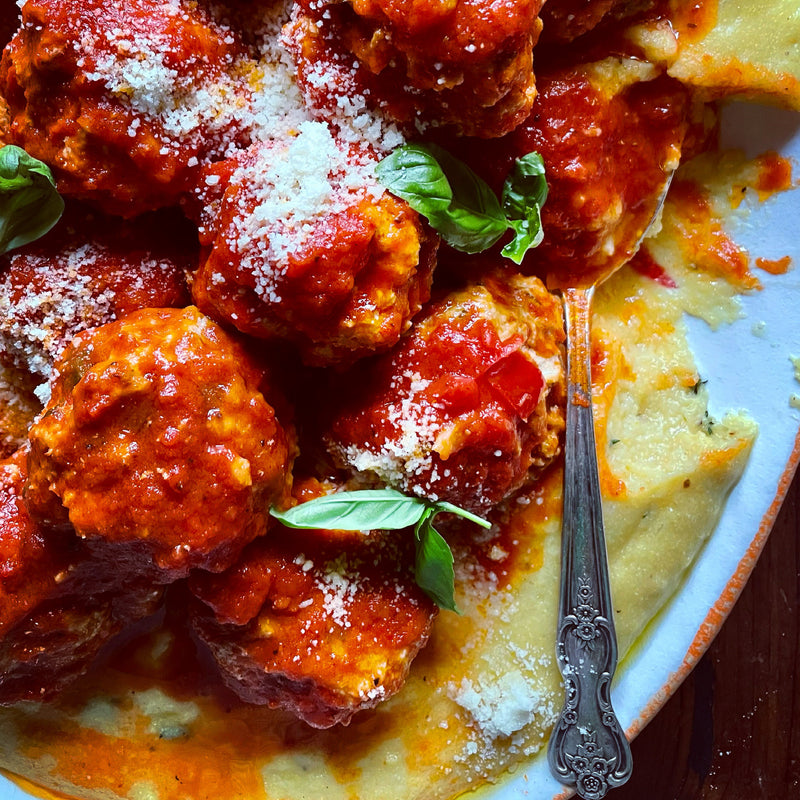 Polenta and turkey meatballs with red sauce on platter
